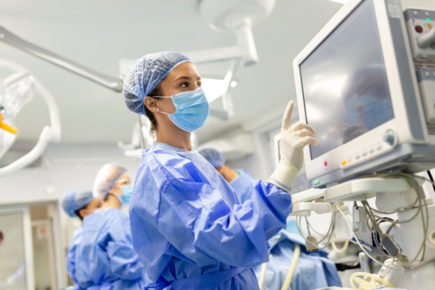 Female plastic surgeon using ultrasound technology while performing Brazilian butt lift (BBL) surgery