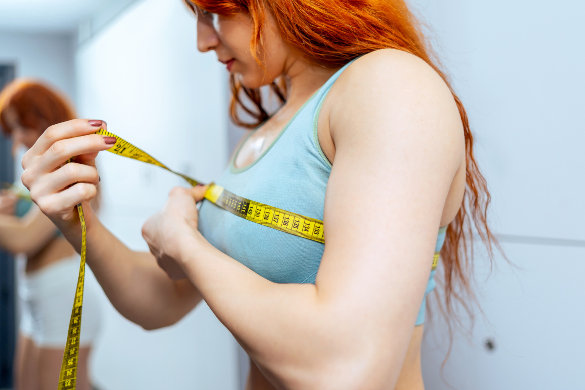 Woman taking bra measurements with measuring